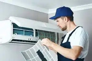 Technician installing new furnace filter in Calgary basement