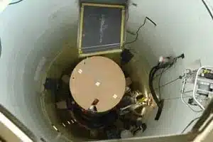 Technician cleaning sump pit in Calgary home