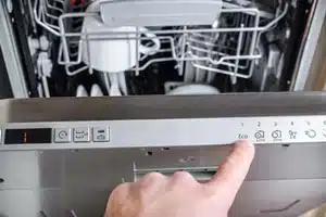 Plumbing technician checking dishwasher drain in Okotoks