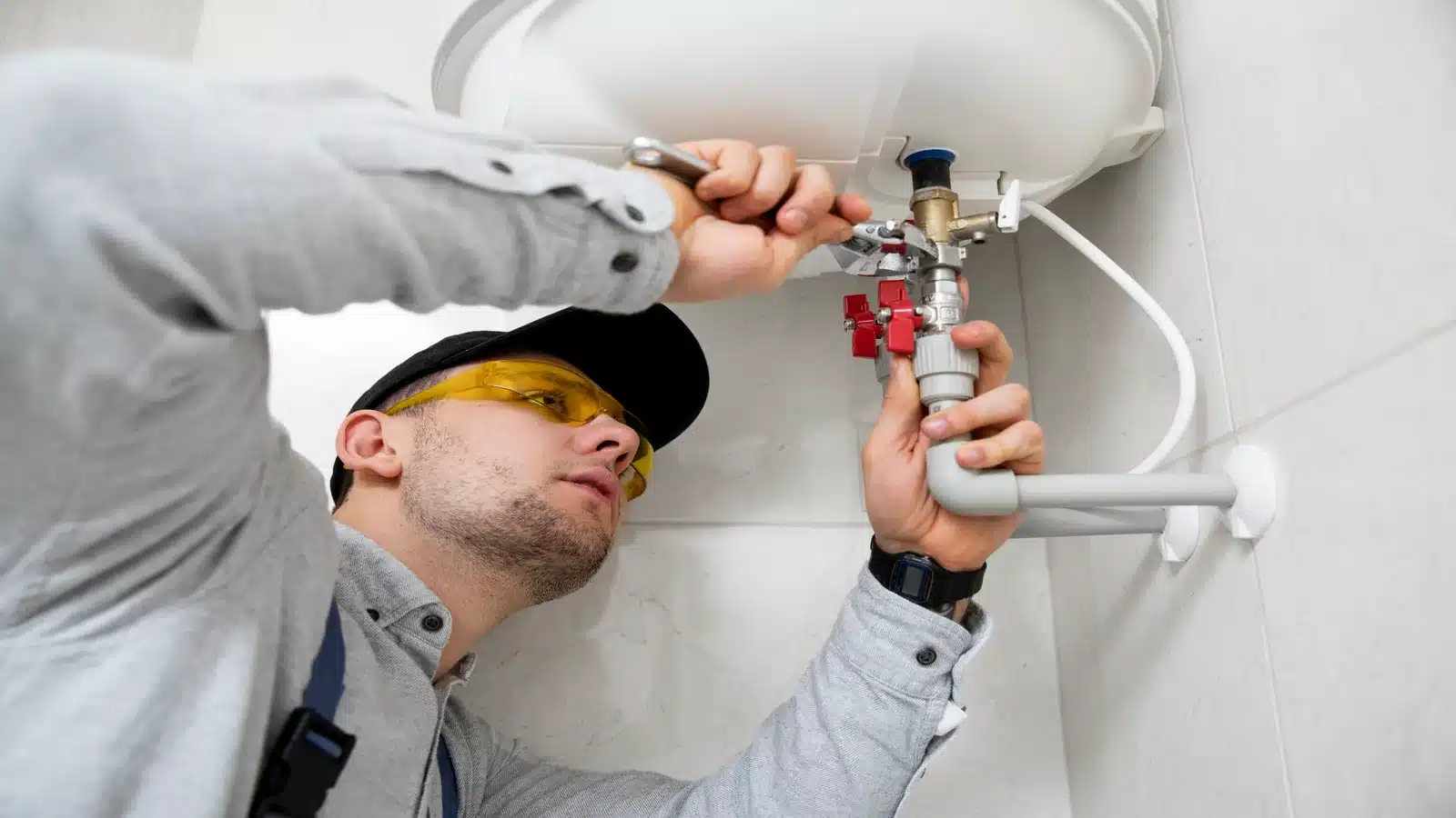 Plumber repairing leaking water heater in Calgary