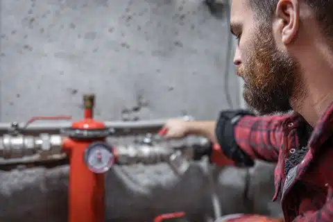 Technician inspecting sprinkler system gauge