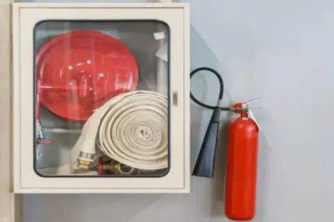 Wall-mounted fire extinguisher with compliance signage