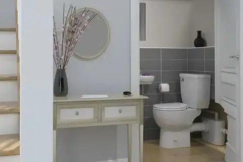 Expert plumber installing a Saniflow toilet system in a modern Calgary home bathroom setup